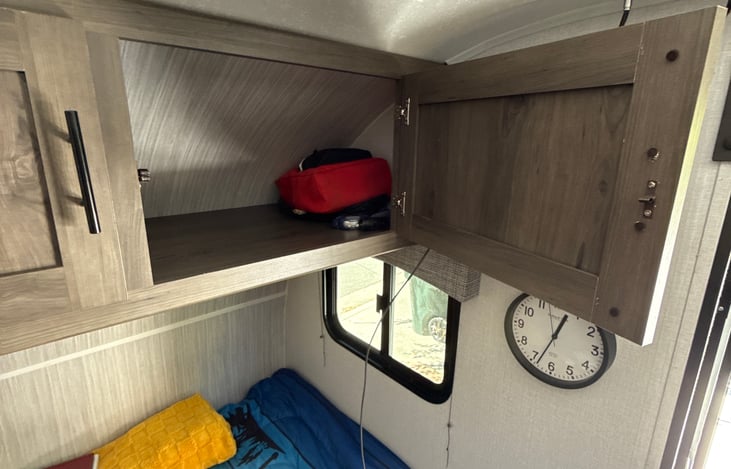 First aid and flashlights in the cabinet left of the tv and clock.