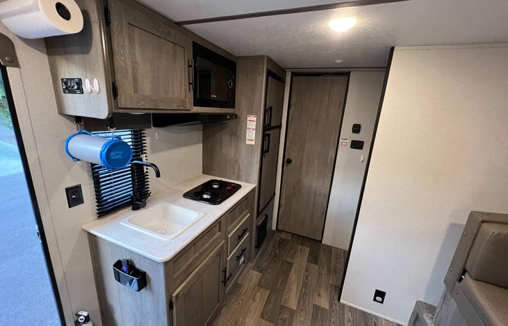 Kitchen area with sink, 2 burner stove, and fridge/freezer