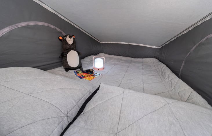View of pop top sleeping area with zip open windows