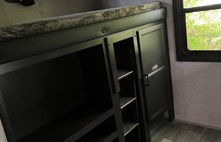 Top (Single) Bunk, 32" TV, and Storage Space.