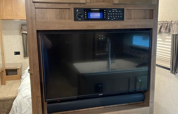 Main area TV with surround sound/bluetooth AM/FM Stereo system.