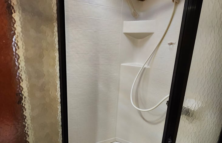 Bathroom shower, door open.