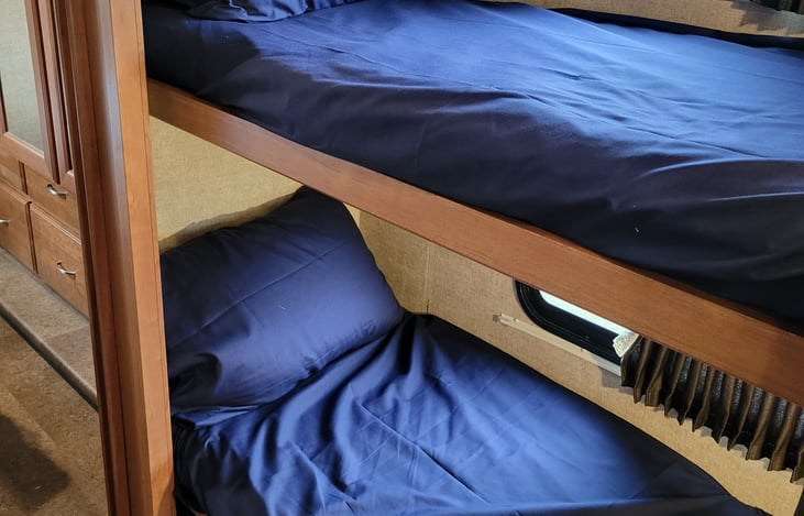 Bunk beds can convert to storage. Under bottom bunk are extra pillows and sheets for all beds if needed. Extra throw blankets are also there for comfort or to use at the bonfire!