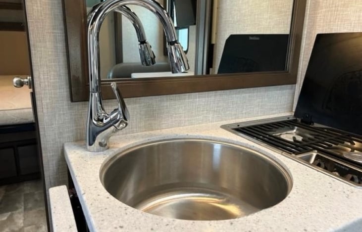 Deep under mount stainless steel sink and arched pull-down kitchen faucet.