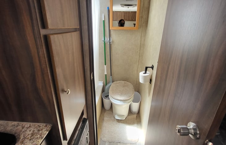 view of rest room has toilet tub/shower and a sky light I'm six foot four inches tall and can close the door when seated comfortably