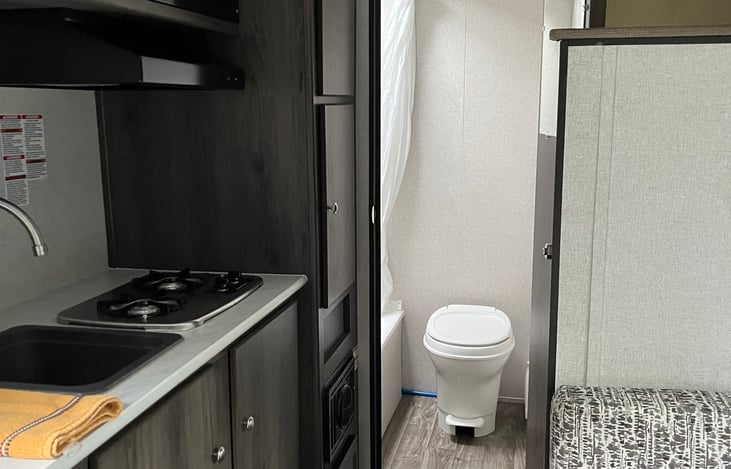 Kitchen with microwave, cook top, frig, Kerig, toaster and dining table that converts to bed.