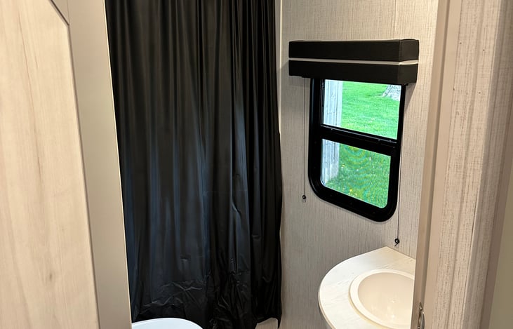 Nice-sized bathroom w/ toilet, sink, mirror storage, full shower w/ tub.