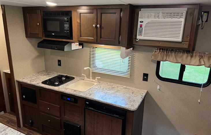 Kitchen with two burner stove, microwave and sink.
Cabinets with plenty of storage.