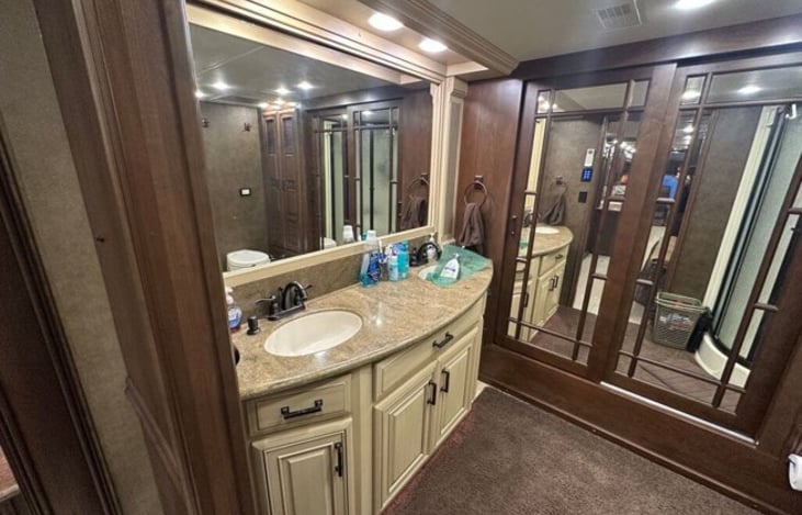 The master bath features a dual vanity sink, shower, closet for your hanging things, mascerating toilet, and the washer and dryer.