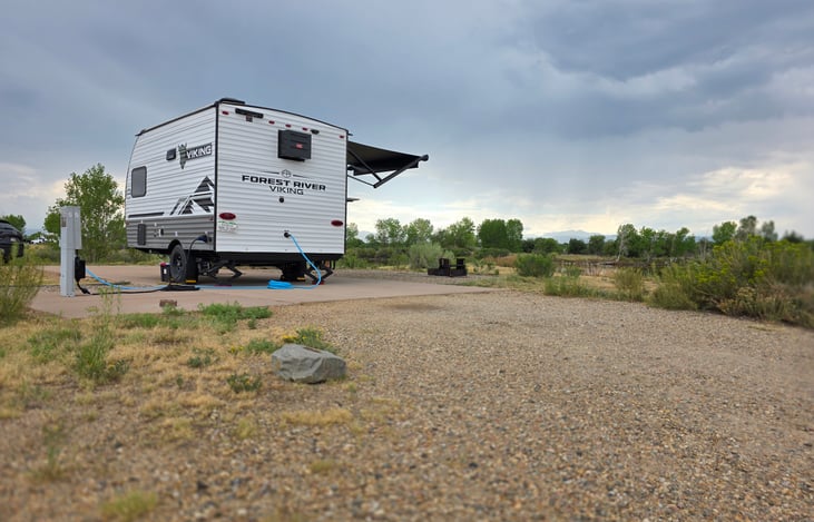 The Hibernation Station at a full hook up site watching an afternoon storm roll over the mountains
