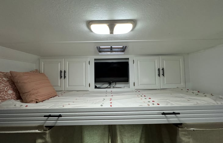 Extra long twin above driver and passenger seat with extra blanket storage.