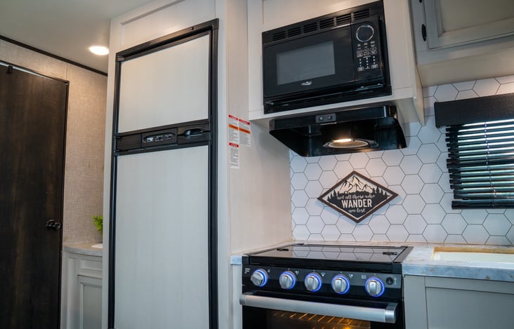 Fully equipped kitchen includes farm style sink, oven, three burner stove, microwave, and full sized fridge and freezer.  Stocked with all kitchen essentials including coffee maker.
