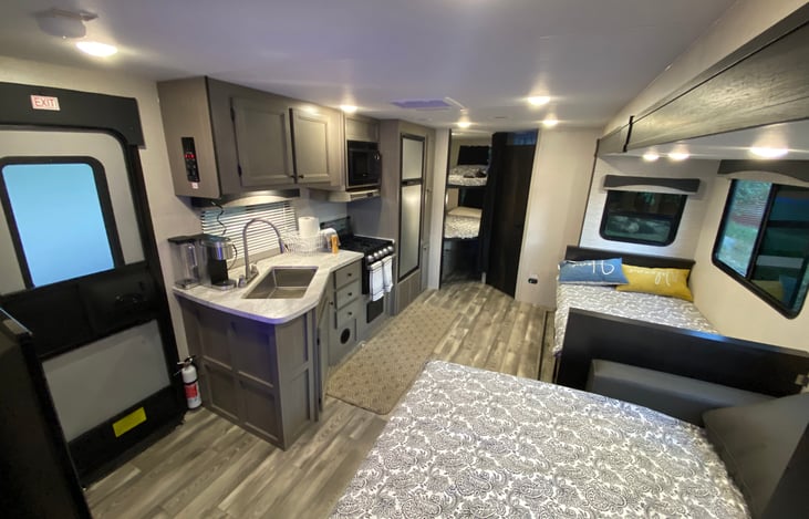 Slide out, kitchen, exit, and bed views (sleeps 4x + 4x on bunks)