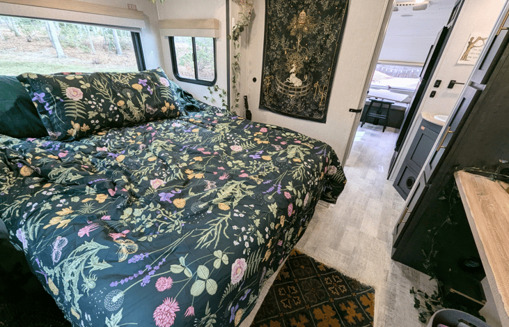 Comfortable, bright, and spacious bedroom slideout with Queen bed, large TV and whimsical touches to make it feel cozy and magical.