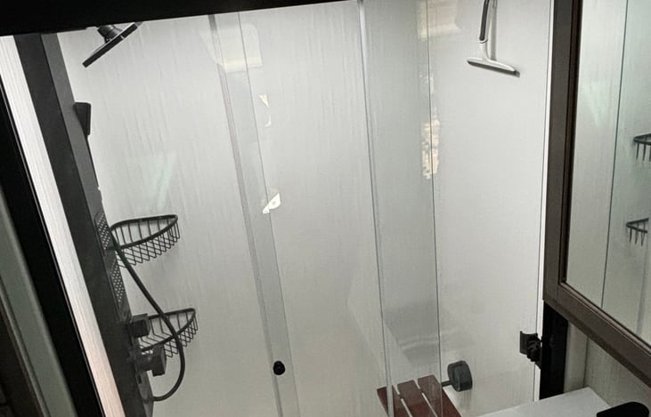 Another view of shower with seat down.  Hot water heater can be powered via gas or electricity so there will never be a cold shower!