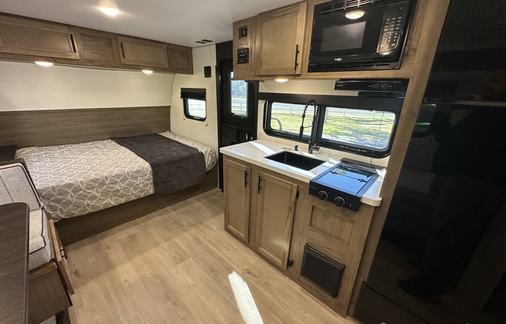 Kitchen and bed overview showing compact layout and walkway.