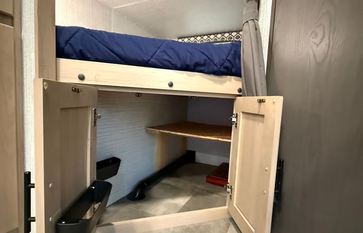 Large under-bunk storage area with shoe organizers and plenty of space for bags and gear.