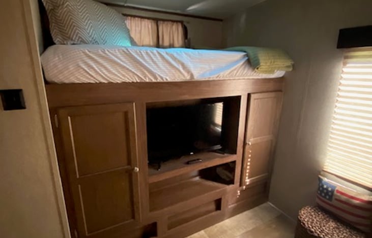 Bunk and entertainment center to the left side of bunkhouse.