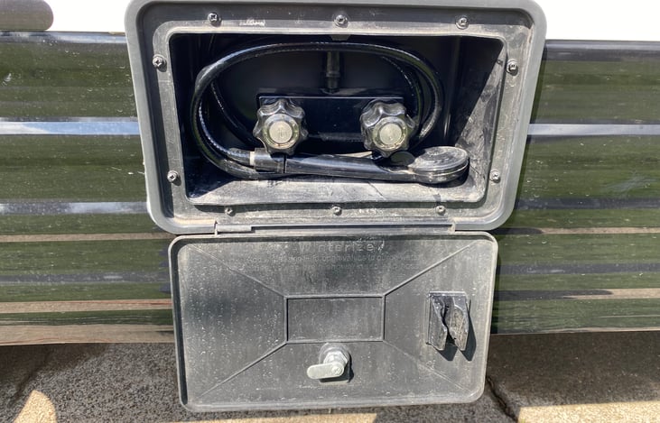 Left side of RV: Outdoor shower with hot and cold knobs