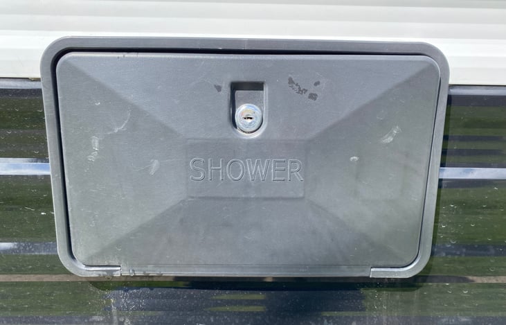 Left side of RV: Outdoor shower cover closed