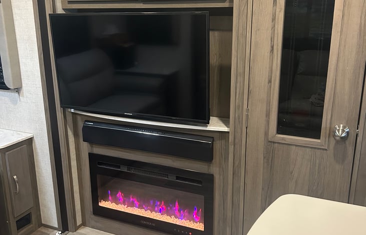 TV, Bluetooth speaker with indoor and outdoor speakers, and electric fireplace.