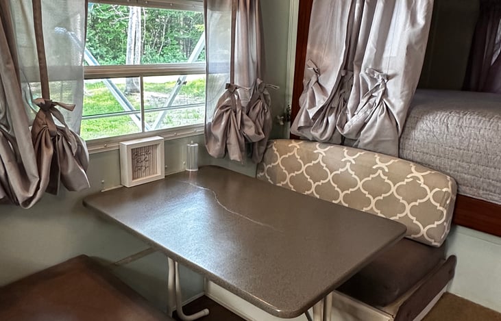 Kitchen dinette table, which can collapse down into a bed for 1 to 2. Storage underneath with extra bedding and a drawer with games for family fun.