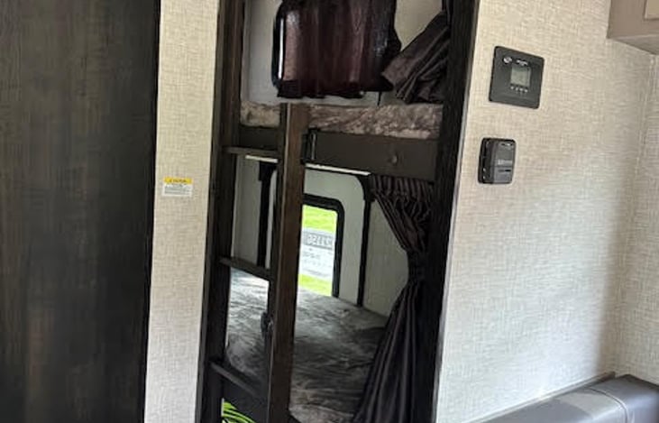 Ladder folds back into the wall after use and curtains shut for privacy.