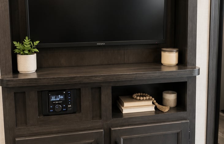 Modern entertainment center with smart TV, premium indoor/outdoor sound system, hidden storage, and luxury dark wood finishes for cozy movie nights and campsite vibes. 📺🎶