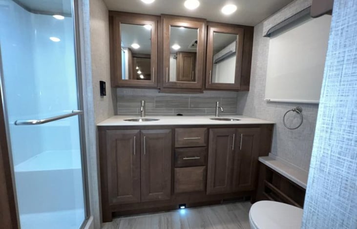 main bath with dual sink and shower