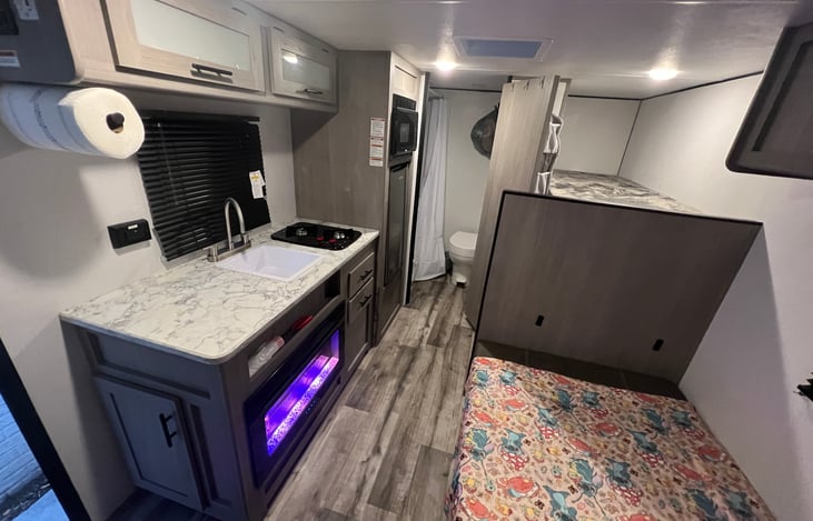 Electric fireplace as a heater. Has cool light settings and super warm. Small sink and 2 burner stove.