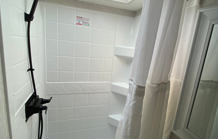 Shower area includes bath rug.