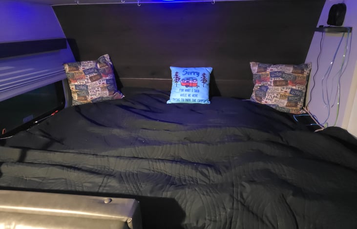 Primary Queen bed with nightlight, small fan, shelf, Wirelesa Phone Charger.  Bedding not included.