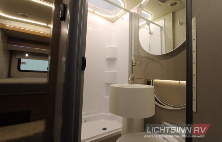 Bathroom area has shower with solid shower cover, sink that rotates & toilet that flushes just like toilet at home.  Very nicely engineered.