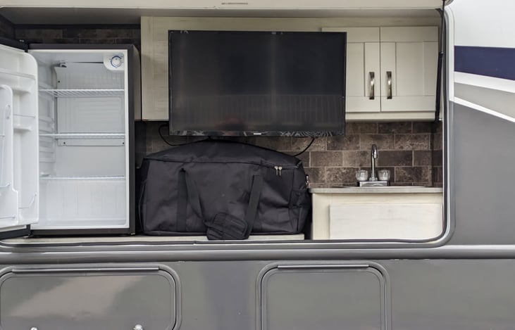 Outdoor kitchen and sink with outdoor tv.