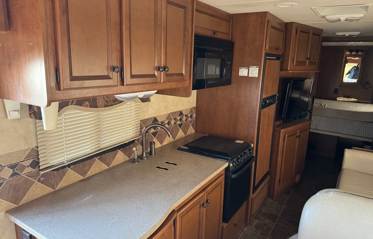 Kitchen area with microwave , stove top and oven!! Refrigerator and freezer as well runs on electric or propane