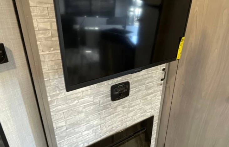 32” Roku TV amd electric Fireplace that changes LED colors. And behind the TV wall is a hidden pantry (where we have dishes)