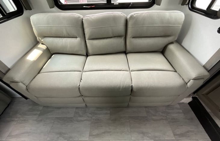 Spacious and luxurious elevated Front Living Suite with opposing slide-outs that create a massive theater-style room separate from the kitchen. 3 couches, warm fireplace and large flat-screen TV make