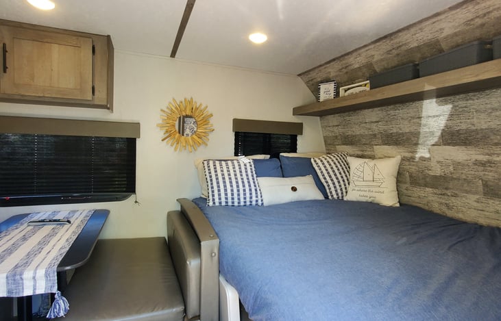 Bed w/down comforter, 4 standard pillows, decorative pillows, extra storage bins, wall hanging & linens featured in the Glamping Package Addon
