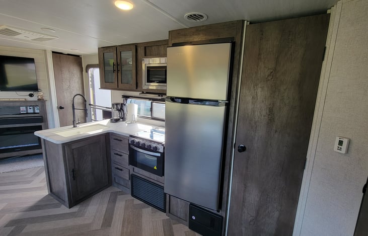 Kitchen | 3 burner stove and oven | 10.7 CU FT 12 volt Refrigerator | Microwave