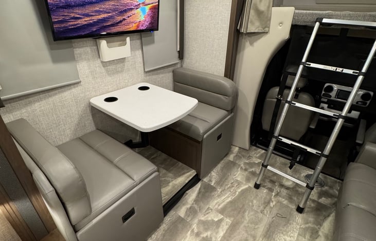 Dinette with operable windows next to each seat, manual room darkening shades. Table has 2 built in cup holders. Power outlet under the able, as well as 2 USB power connections.
