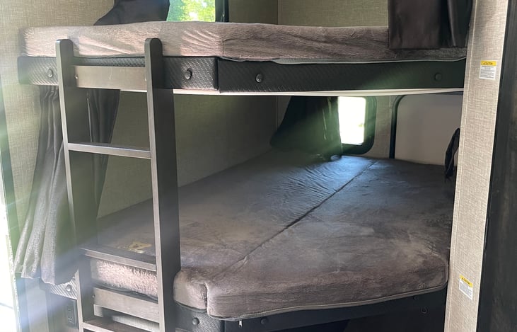 Full size double bunks. Curtains for privacy. Aux chargers in bunks for kids devices. Windows for light/air movement. Under bunk storage. Ladder to access top bunk. Sleeps 2 adults. (4 small kids)
