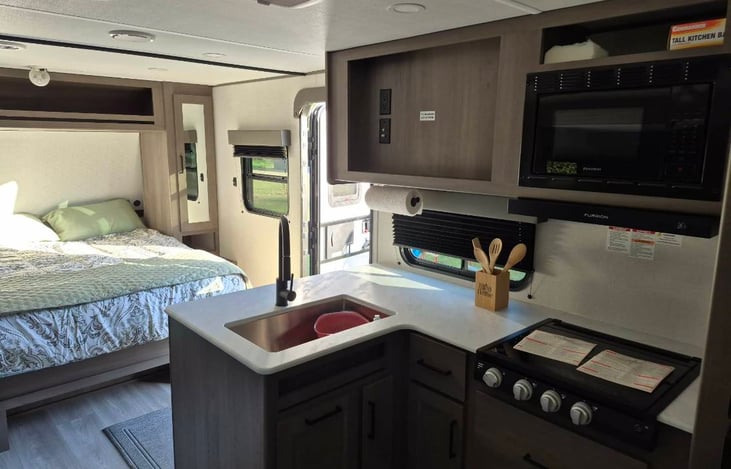 Modern luxury inside! Features a private master queen, double bunks, a huge U-shaped dinette slide-out, a fully loaded kitchen, a 10.2 cu ft fridge, a full bath, and premium JBL sound.