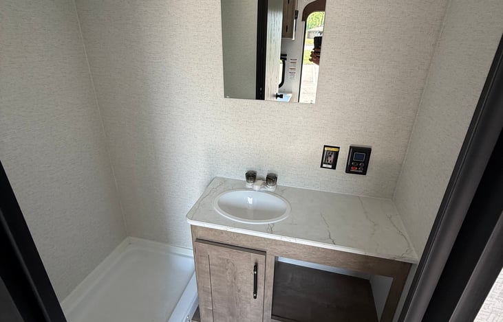 Bathroom with toilet, sink, and shower