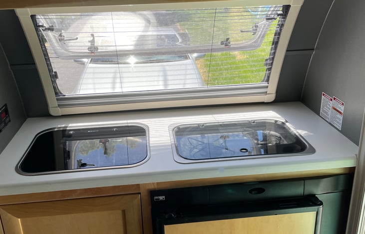 A small sink, stovetop, electric water pot, and hot plate are included!