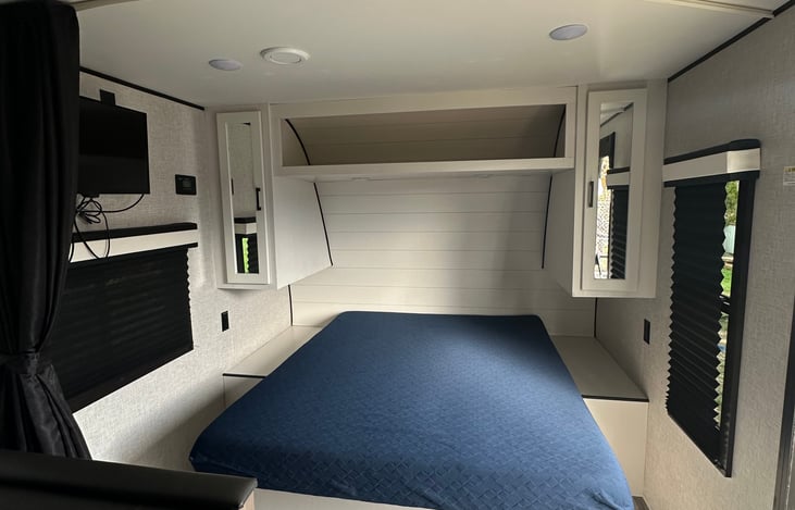 Queen bed with privacy curtain.