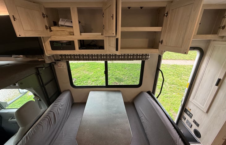 Ample storage above the kitchen/game table. DVD player (generator required) provided and sound system. Sticky pads on the far left cabinet to help those games from moving around.