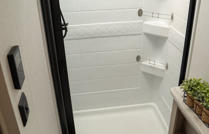 Stand up shower with sliding door is just like home. Tankless water heater means endless hot water when camping with full hookups.