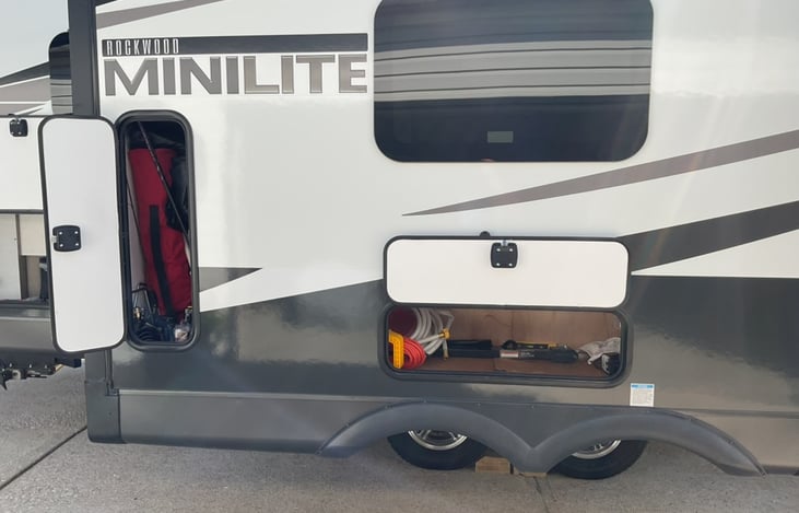 Storage compartments in slide out. Calapsable chairs, stabilizer jack pads, levelers, fresh water, black water, sewer hookups, air compressor, tool box, etc.