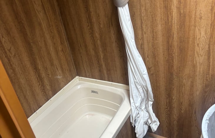 Features a deep soaking tub, shower curtain, and a functional layout perfect for keeping clean and comfortable while camping