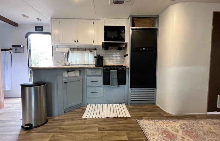 Full kitchen, with microwave, range top, oven and refrigerator.